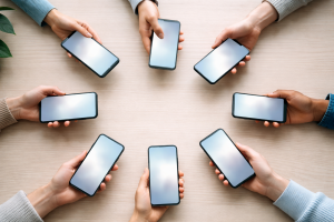 Visuelt, mere abstrakt billede til mission/vision, der symboliserer forbindelse og kommunikation – fx flere hænder med forskellige smartphones over et bord med bløde linjer og lys.